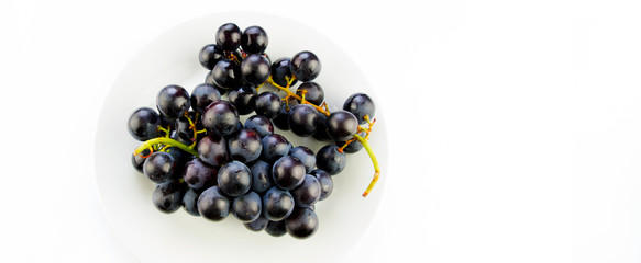  Tasty fresh black grape in a bowl and on white background