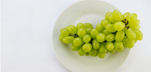 tasty fresh green grape in a bowl and on white background