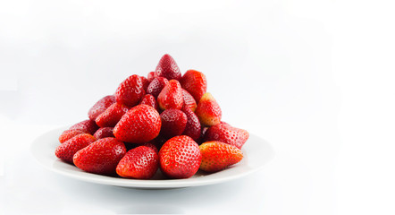 Tasty fresh red strawberry in a bowl and on white background