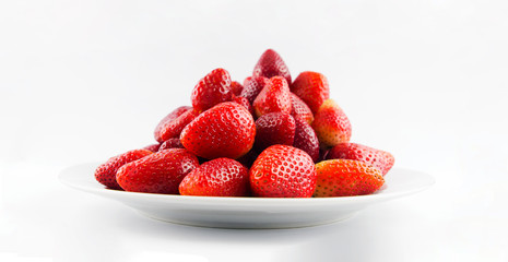 Tasty fresh red strawberry in a bowl and on white background
