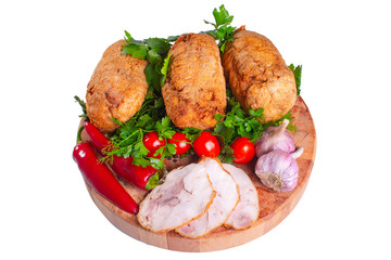 Meatloaf with greens and vegetables on a wooden round board on a white isolated background