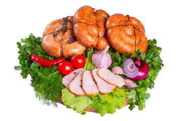 Sausages with tomatoes and greens on a large round board on a white isolated background