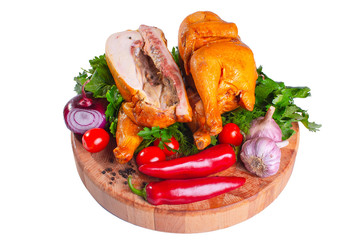 Smoked chicken with herbs and tomatoes on a wooden round board on a white isolated background