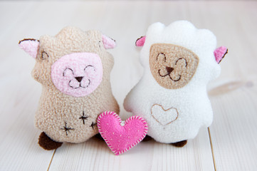 two soft toy sheep handmade on a light wooden background