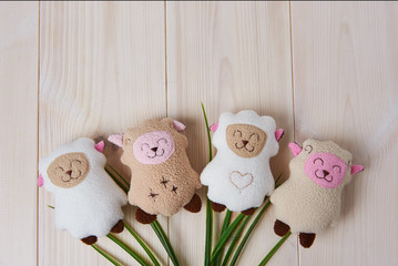 few cute handmade soft toys on a light wooden background, top view