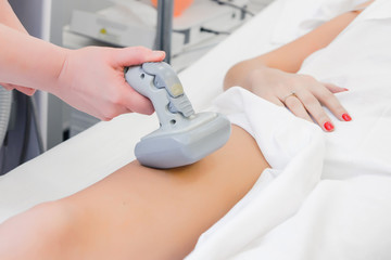 Obraz na płótnie Canvas Vacuum massage of the abdomen of a young girl. Instrumental cosmetology. Spa Studio. Rejuvenation and skin tightening