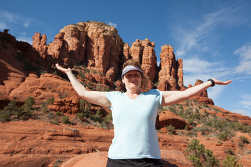 woman hiker raises arms at the peak of chicken point in sedona arizona