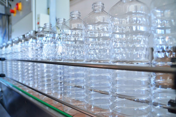 Bottle. Industrial production of plastic pet bottles. Factory line for manufacturing polyethylene bottles. Transparent food packaging