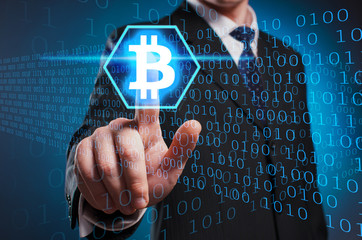 Bitcoin. A man in a suit and tie clicks the index finger on the virtual screen. Exchange crypto...