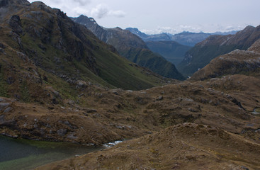 Peaks peeking at the distance behind the valley at the Routeburn Great Walk in Fiordland in New Zealand