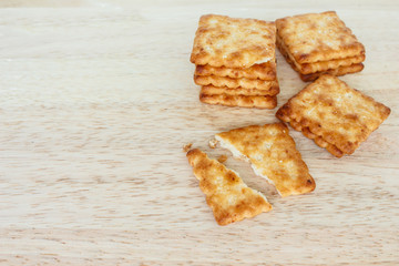 Crackers broken in half top view on wooden background.