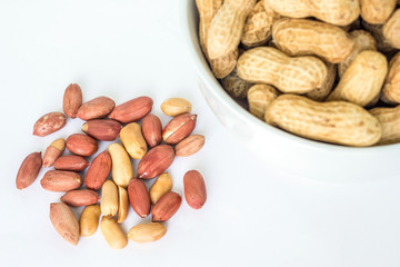 peanut pile in white bowl top view on white background