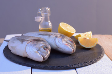 dorado fish on a black plate with lemon
