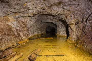 Underground abandoned gold iron ore mine shaft tunnel gallery passage with water flooded