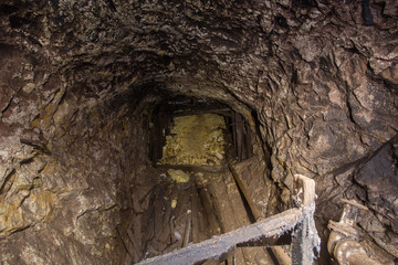 Underground abandoned gold iron ore mine shaft tunnel gallery passage with timbering wooden