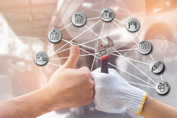 Mechanic hand checking and fixing a broken car in  garage.hand of mechanic with thumbs up and tool