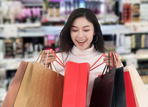 surprised woman holding opened shopping bag at mall
