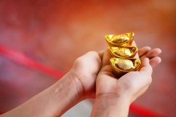 Close up hand woman holding piece of gold weighing ten baht. Pure gold The gold is stored, Considered a good asset. Play high-risk gold stocks should also have expert advice. Gift in Chinese New Year