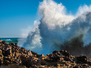 Fototapeta na wymiar Large wave exploding over rocks