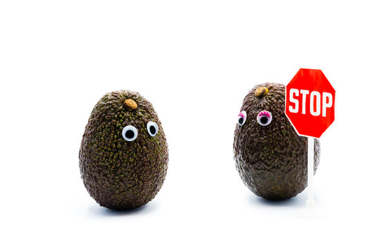 Romantic avocados couple with googly eyes as man and woman, STOP traffic sign, funny food concept for creative projects