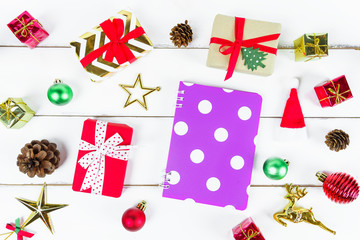Christmas New year theme object (gift box ,Santa sock, sun glasses, ultra violet notebook, star, pine cone, reindeer, hat) decorated on white wooden table desk and background.Holiday festival concept.