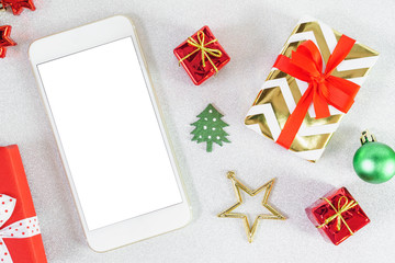 Close up mobile smartphone white screen with copy space for text Christmas New year theme red craft gift box ribbon bow with golden star on glitter background.