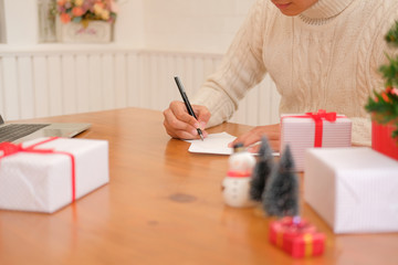 man writing christmas letter greeting card holiday wishes with xmas decoration