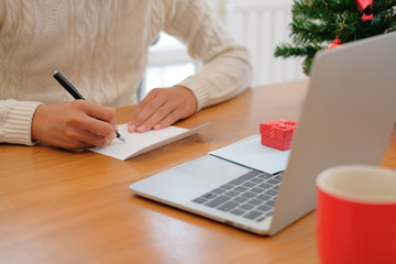 man writing christmas letter greeting card holiday wishes with xmas decoration