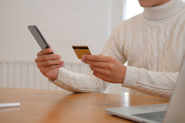 man holding credit card & smart phone for online shopping.  male buyer buying on internet.