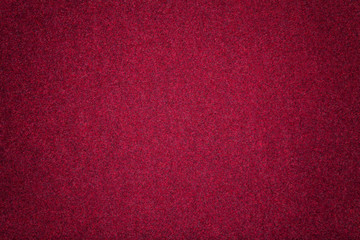 Dark red matt suede fabric closeup. Velvet texture of felt.