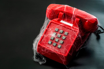 Obsolete technology and abandoned telephone concept with a vintage phone covered in spider webs...