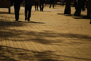 people walking on the street at sunset