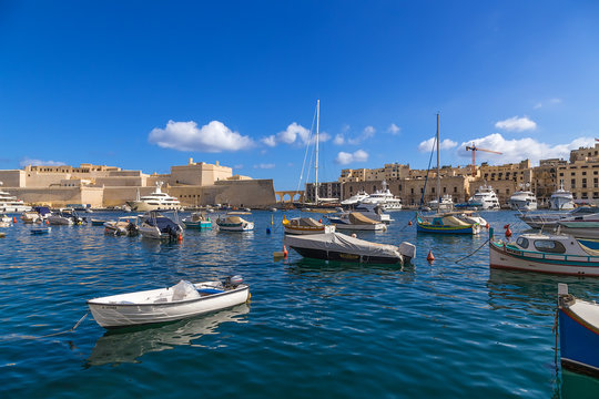 Birgu, Malta. The picturesque boat harbor on the background of Fort Saint Angelo and the city