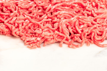 Minced meat on a white marble kitchen surface with copy space