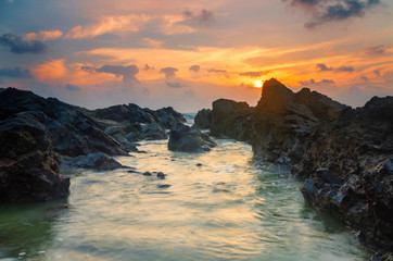 beautiful sea view with unique rock formation scenery over stunning sunrise and cloudy sky background.