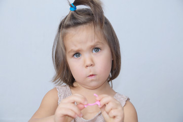 Surprised and disconcerted little girl portrait. child funny face with expressive emotion. emotional toddler frightened at gray background.