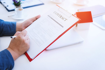 Close up hand of business man signing contract documents on office. Law and Legal concept.