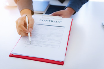 Close up hand of business man signing contract documents on office. Law and Legal concept.
