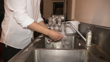 Man 1 is washing a glass of wine.