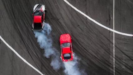 Foto auf Acrylglas Bestsellern Sport Luftaufnahme mit zwei Autos Drift-Kampf von oben, Aktivität zwei Autos Drift-Action-Kampf auf Asphalt-Rennstrecke mit abstraktem Rauch.