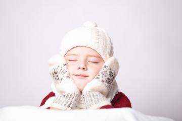 Merry Christmas and happy New year! Cute happy little child boy. Kid enjoy holiday in warm clothes. Portrait kid on light background isolated. Dreaming Child with place for text