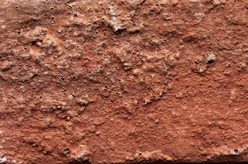 Macro shooting texture of red clay wall. Red clay earth for background usage. Texture of the old tough cragged wall of red color