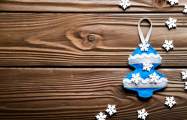 Handmade rustic felt Christmas tree decorations on wooden table