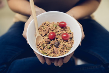 Young beautiful woman take care her health by eating milk with multi grains granola in morning