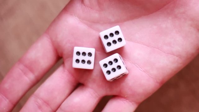 Three dice number six in male palm