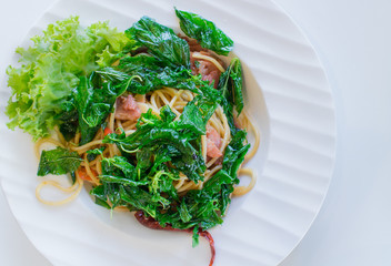Spicy spaghetti  with bacon, basil  and dried chilli, serving on white plate