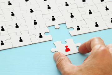 image of puzzle with people icons over wooden table ,human resources and management concept.