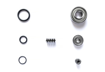 Top view of spare parts is bearing with tire ring and spring are small placed on white floor.