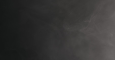 Slow motion closeup vapor floating in air on black background