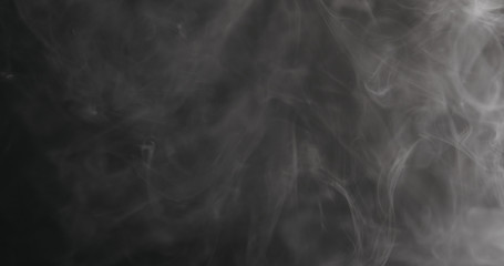 Slow motion closeup vapor floating in air on black background